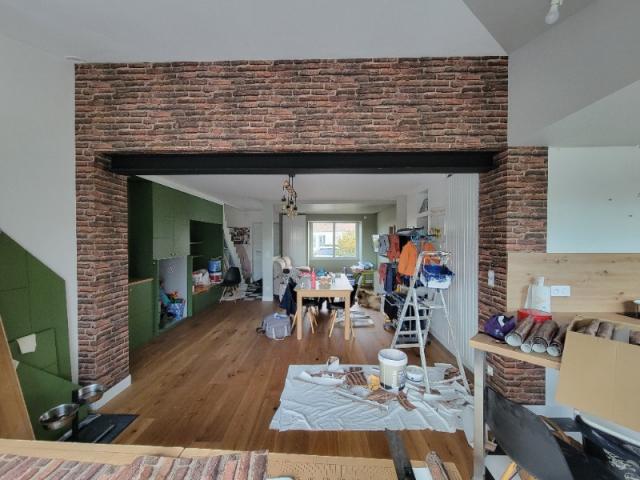 Papier peint brique pour sublimer un mur soutenu par une poutre métallique noire